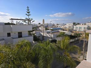 a view of a city with palm trees and buildings at Bilocale zona spiaggia Home Salento com in Torre San Giovanni Ugento