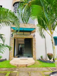 a building with a palm tree in front of it at Résidence Ephrata in Cocody