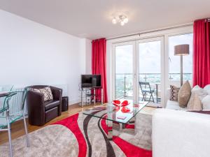 a living room with a white couch and a glass table at Tides in Poole