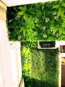 a wall covered in green ivy with a sign on it at Kuća za odmor Aqua Vet Velika Kladuša in Velika Kladuša