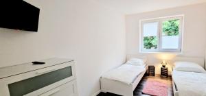 a small white room with a tv and a couch at Ferienhaus Strandallee 10 in Burhave