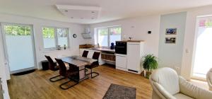 a living room with a table and a kitchen at Ferienhaus Strandallee 10 in Burhave +3 photos