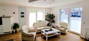 a living room with two chairs and a coffee table at Ferienhaus Strandallee 10 in Burhave