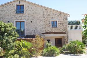 una vista exterior de una casa de piedra con plantas en La Bastide de l'Olivier, en Le Muy