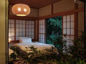 a bedroom with a bed and a large window at shinso hakone in Hakone