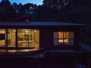 a house with large windows and a deck at night at shinso hakone in Hakone