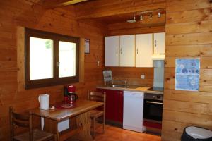a kitchen in a log cabin with a wooden table at Les castors in Roubion +14 photos