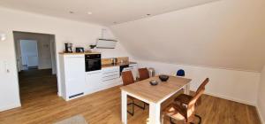 a kitchen and dining room with a table and chairs at Ferienhaus Strandallee 10a in Burhave
