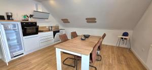 a kitchen with a wooden table and chairs in a room at Ferienhaus Strandallee 10a in Burhave +10 photos