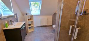 a bathroom with a shower and a sink and a toilet at Ferienhaus Strandallee 10a in Burhave