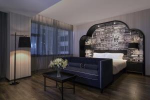 een slaapkamer met een bed en een blauwe bank bij Crystal Orange Hotel Guangzhou Taojin Branch in Guangzhou +41 foto's