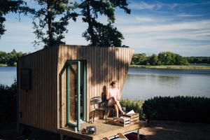 a woman sitting in a chair in a tiny house at Tiny Houses Klein Ahoi Camp Canow in Wustrow