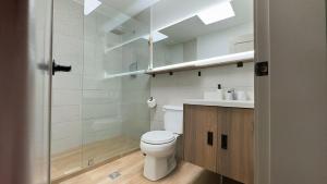 a bathroom with a toilet and a sink and a shower at La Carolina Suite Moderna - Excelente Ubicación in Quito