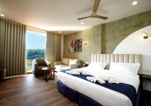 a hotel room with a bed and a couch at River Bay Athirappilly in Athirappilly +34 photos