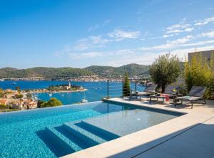 ein Schwimmbecken mit Blick auf das Wasser in der Unterkunft Breathtaking Villa Vis in Vis
