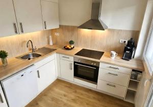 a kitchen with white cabinets and a sink at Pferdeparadies Untergrünhagen in Bad Fallingbostel +8 photos