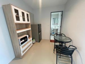 a small room with a table and chairs and a kitchen at Bell Lifestyle Hostel Phuket in Nai Yang Beach