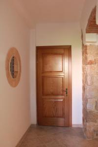 a wooden door in a room with a stone wall at Sa dommu de pedra in Santa Maria Navarrese +4 photos