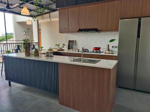 a kitchen with wooden cabinets and a large kitchen island at The Orchid by FLAT06 in Jakarta
