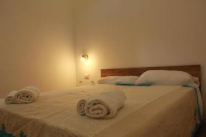 a bedroom with two white towels on a bed at Sa dommu de pedra in Santa Maria Navarrese