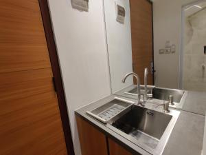 a kitchen with a sink and a mirror at The Orchid by FLAT06 in Jakarta +23 photos