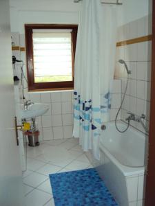 ein Bad mit einer Badewanne, einem Waschbecken und einer Dusche in der Unterkunft Apartments Ski Sonne Rehe in Rehefeld-Zaunhaus