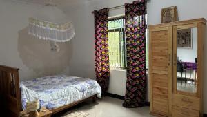 a bedroom with curtains and a bed and a window at Tarangwe Homestay & Hostels in Iringa