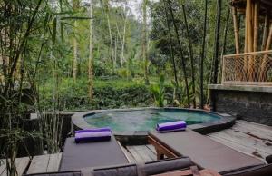 a hot tub with purple cushions sitting on a deck at Panorama Sidemen in Silebeng