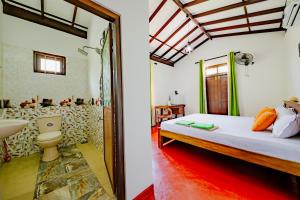 a bedroom with a bed and a bathroom with a sink at Kataliya Villa in Ahungalla