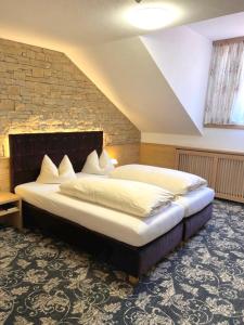 a bedroom with a large bed with a brick wall at Gasthof & Hotel Jägerwirt in Aufhofen