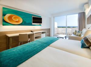 a hotel room with a large bed with a desk and a tv at Globales Panamá in Palmanova