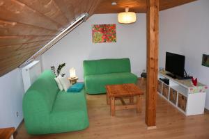 a living room with a green chair and a table at FeWo Wacholderheide in Langenau