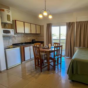 a kitchen and dining room with a table and chairs at Urunday Apart Hotel in Posadas