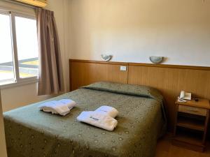 a bedroom with a bed with two towels on it at Urunday Apart Hotel in Posadas +25 photos