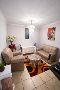 a living room with a couch and a table at PrimeStay One 2 Bedroom Apartment in Johannesburg