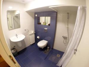 a blue and white bathroom with a toilet and a sink at Beit Wadih in Ghazīr
