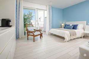 a bedroom with a bed and a chair and a window at Madau's House Exclusive Apartments in Olbia