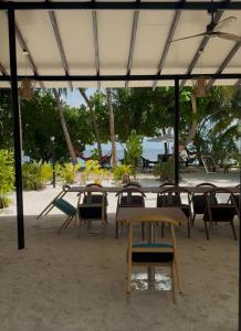 a group of tables and chairs on a beach at LVIS Pool Villa in Dharavandhoo