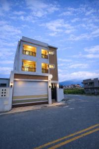 a white building with a garage door and a building at Bird Walking in Yuli