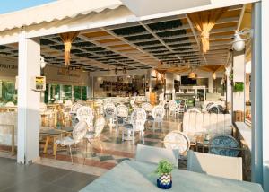 a restaurant with white chairs and tables on a patio at Hotel Panorama in Koukounaries