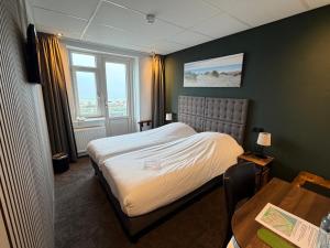 a hotel room with a bed and a table at Hotel Zee en Duin in Katwijk