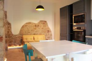 a kitchen with a table and chairs and a couch at Sa dommu de pedra in Santa Maria Navarrese