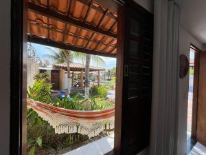 a door leading to a patio with a hammock outside at Espaço Ybirá in Marechal Deodoro