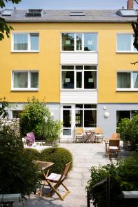 a yellow building with chairs and a patio at Miramar in Helgoland