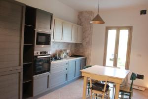 a kitchen with blue cabinets and a table in it at Sa dommu de pedra in Santa Maria Navarrese