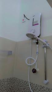 a shower in a bathroom with a sink at Mandara Holiday Home in Anuradhapura