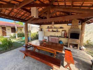 a patio with a wooden table and a kitchen at Espaço Ybirá in Marechal Deodoro