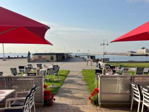 a restaurant with tables and chairs and a red umbrella at Hanseat in Helgoland