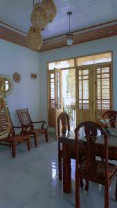 a living room with chairs and a table and windows at Mandara Holiday Home in Anuradhapura
