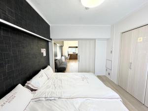 a bedroom with a large bed with a black wall at K-ART Stay Shinsakae2 in Nagoya